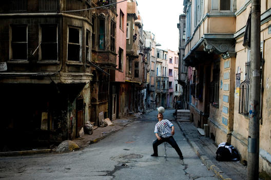 Man performs with a football in the district of Tarlabasi Istanbul, where the urban transformation takes places, there are many abandoned houses area.