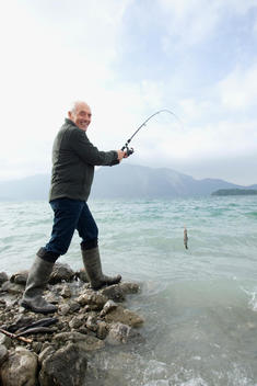 Germany, Bavaria, Walchensee, Senior man fishing in lake