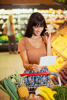Woman talking on cell phone while shopping in grocery store
