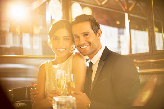 Couple toasting champagne flutes in restaurant