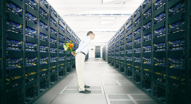 engineer holding flowers behind his back in the Server Room