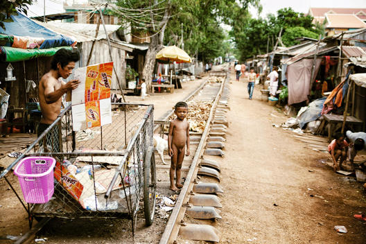 A child stands along the abandoned railroad tracks in the impoverished neighborhood next to Empowering Youth in Cambodia\'s Youth School in Phnom Penh, Cambodia.