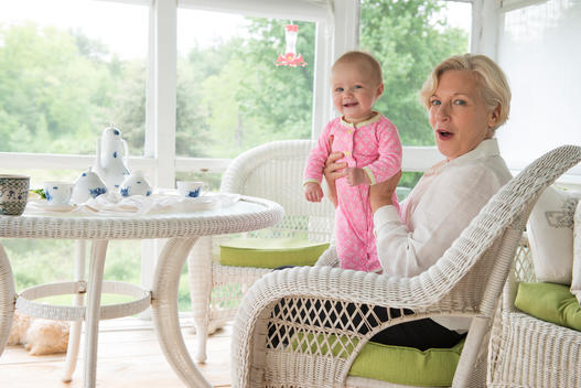 Portrait of a grandmother and granddaughter at a table set for tea