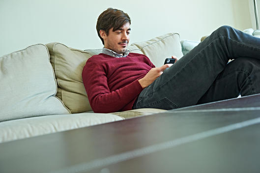 Man using smartphone on sofa