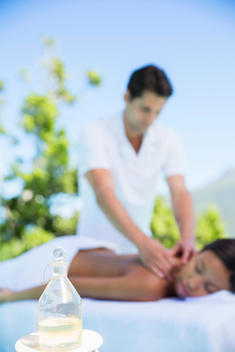 Woman receiving massage on spa patio