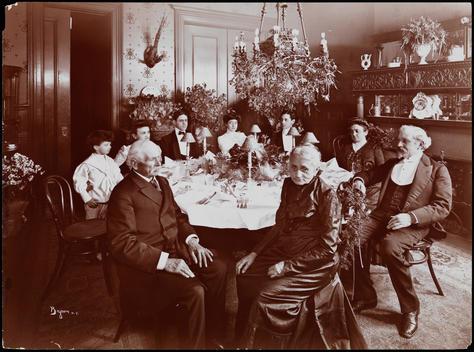 The Dining Room Of The Residence Of Mr. And Mrs. Joseph B. Guttenberg At 118 West 120Th Street On Their Golden (50Th) Anniversary. Family Members Are Seated Around The Table. Flower Arrangements, Chandelier And Fireplace Are Visible.