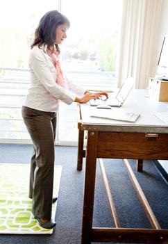 Businesswoman working standing at her desk in office