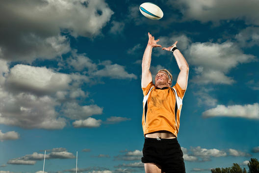 Rugby Player Leaping Up To Catch Ball