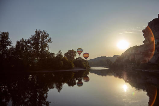2 hot balloons taking off from the Dordogne river in Beynac, France