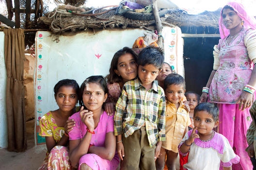 Indian woman and children in front of their rural home wearing traditional clothes and veil