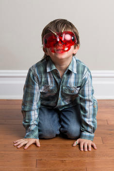 Portrait of young boy, kneeling on floor, wearing mask