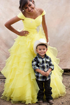Hispanic sister and little brother celebrating quinceanera