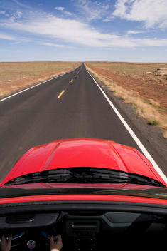 Overhead View Of Red Convertible Driving On Straight Road In The Desert