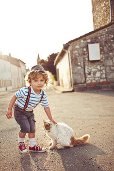 A boy and a cat in the street