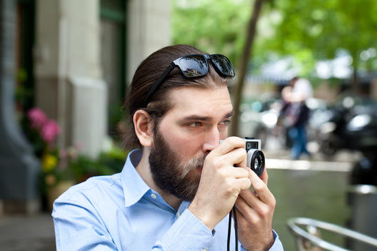 Young man taking picture in street with Old style camera