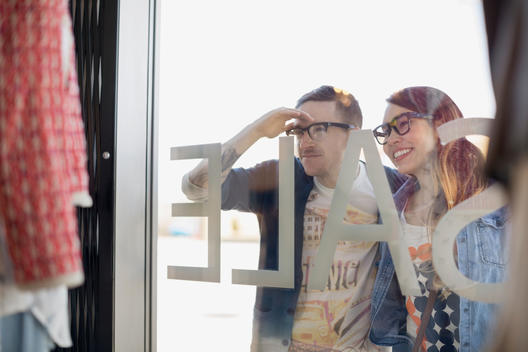Hipster couple window shopping at storefront
