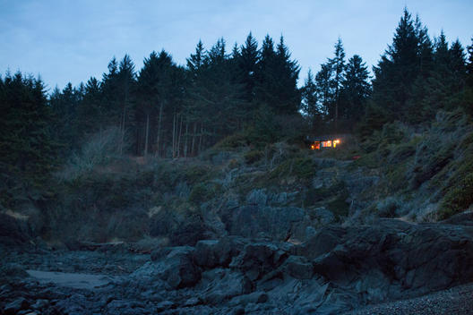 A house illuminated at night on the rocks in Tofino, British Columbia, Canada