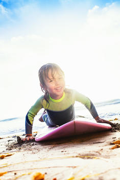 Young girl practicing surfing on beach, Encinitas, California, USA
