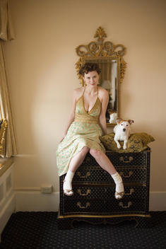 Woman in fancy dress with small dog on dresser