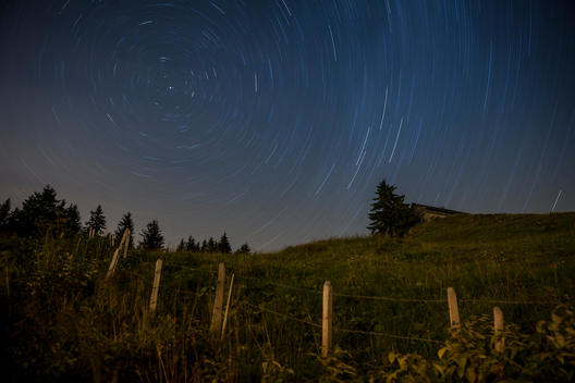 star trails and polaris with farm and house in foreground