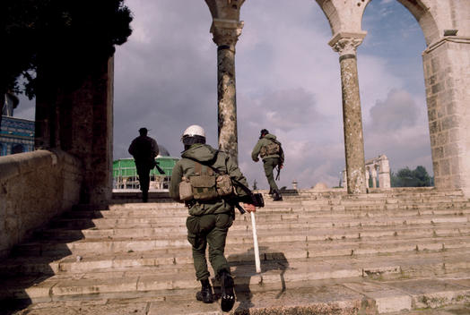 Jerusalem, Israel January 15, 1988 Israeli soldiers move into the Dome of the Rock as Palestinian shout anti-Israeli slogans and burn Israeli and American flags after Friday ceremonies. Israel soldiers shoot tear gas into the Dome as young Palestinians th