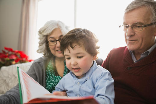 Grandparents and grandson reading book together
