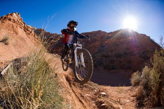 Young boy mountain biking in the desert.