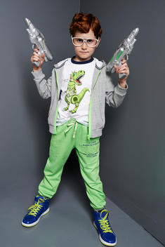 boy with toy gun in a gray studio set