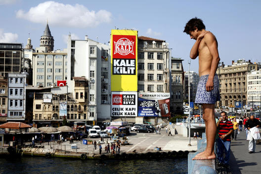 The Young Boy Is Trying To Dive Into The Golden Horn Channel From The Golden Horn Bridge In The Hot And Humidty Summer In Istanbul.