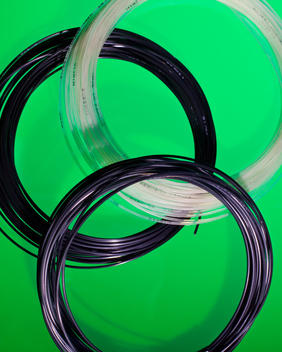 Coiled Tennis Strings On Green Background.
