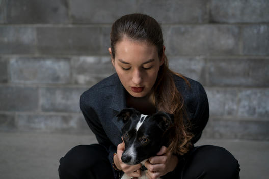 Young woman with red lips crouching over dog
