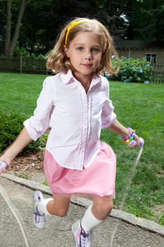 Vertical Action Shot Of Girl In Pink Skirt Doing Jump Rope