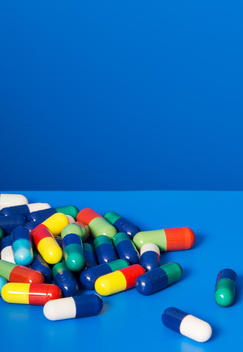 Close up of pile of prescription pills on blue background