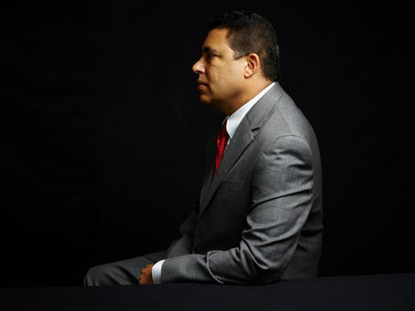Black background portrait of man in suit. Mid 40?s.