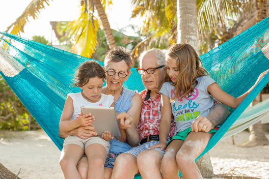 older couple and two young girls sitting in hammock