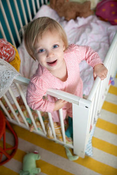 High angle portrait of female toddler in crib