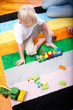 Little boy playing on the carpet of children\'s room