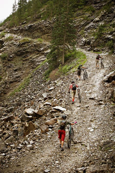 Mountain bikers pushing bikes up hill