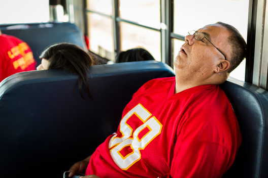 A Kansas City Chiefs fans sleeps on the party bus during the 600-mile road trip to an away game against the Denver Broncos.