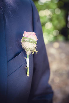 a rose on the suit of the groom, floral decorated