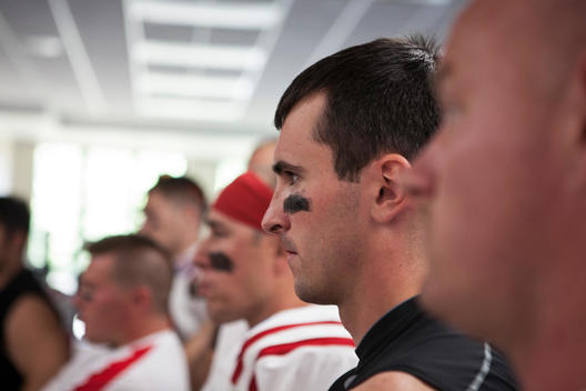 Players listen to their coach prior to a football game in the locker room.