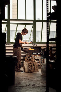 Female owner of a small business blacksmith in her studio