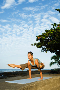 Woman doing yoga pose on wall in Hawaii
