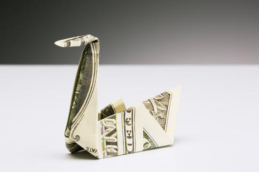 Origami swan made of dollar bill on counter