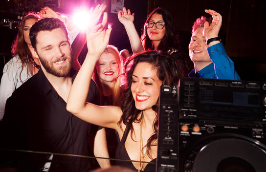 Group of young men and women dancing in nightclub
