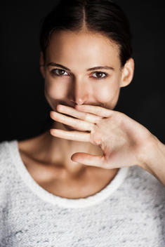 woman smiling covering her mouth