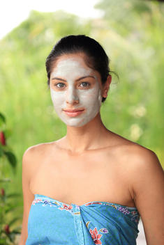 Woman receiving herbal facial-rub treatment