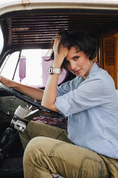 Brown haired girl in the drivers seat of a van.