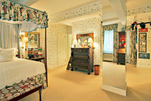 Bedroom With Canopied Wood Four Post Bed, Mirrored Column, Flower Print Wallpaper