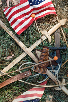 still life of toy weapons and american flags in grass